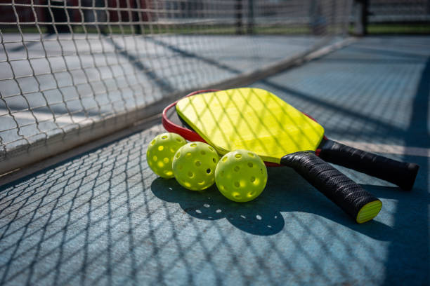 Pickleball paddles and balls on a court surface